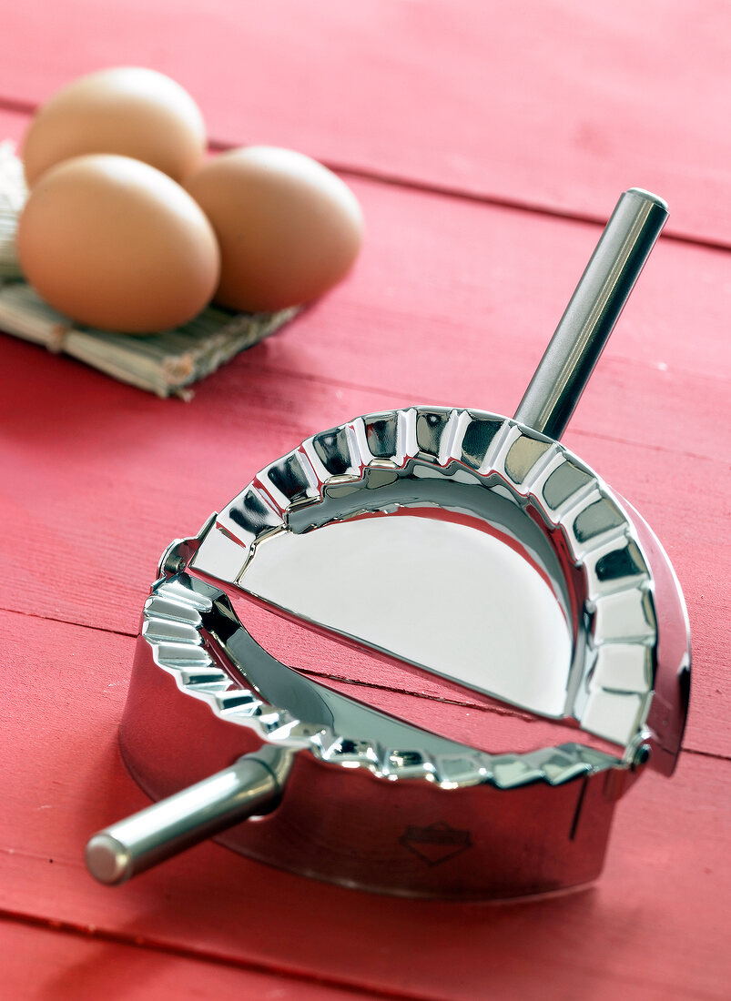 Close-up of ravioli shaper on red background