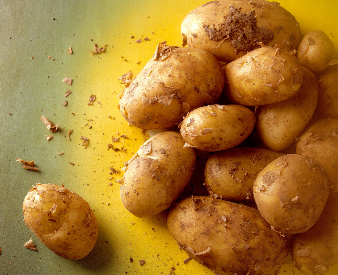 Close-up of fresh organic potatoes on green background