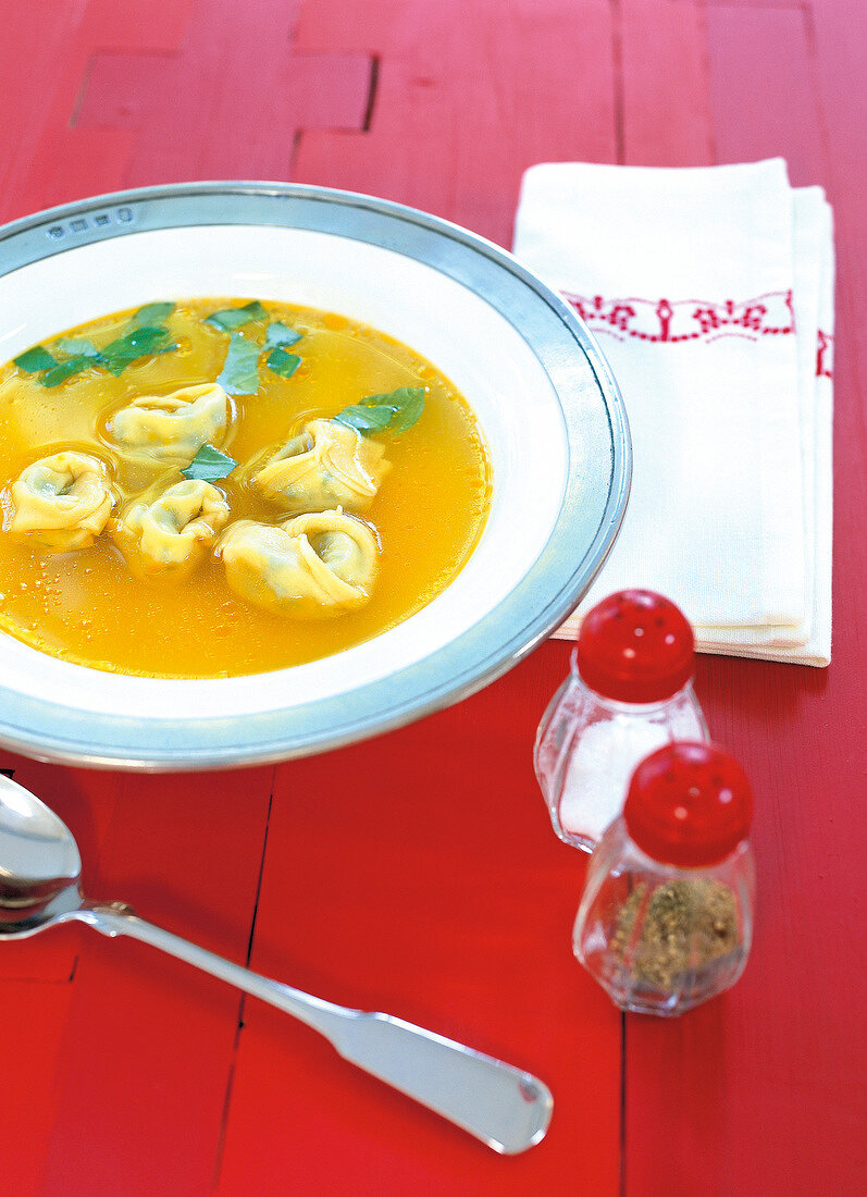 Ricotta tortellini with tomato and beef broth served on plate