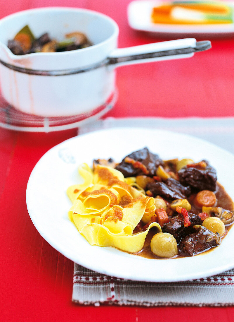 Pasta with meat and burgundy wine served on plate