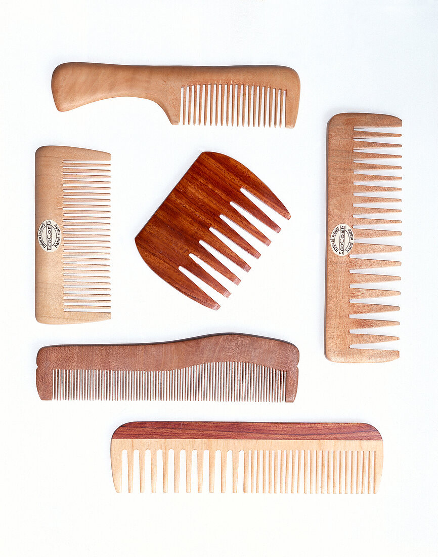 Different brown wooden combs on white background