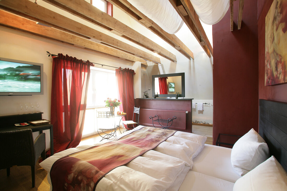 Bedroom with bed, cushion, chairs and table in hotel, Germany