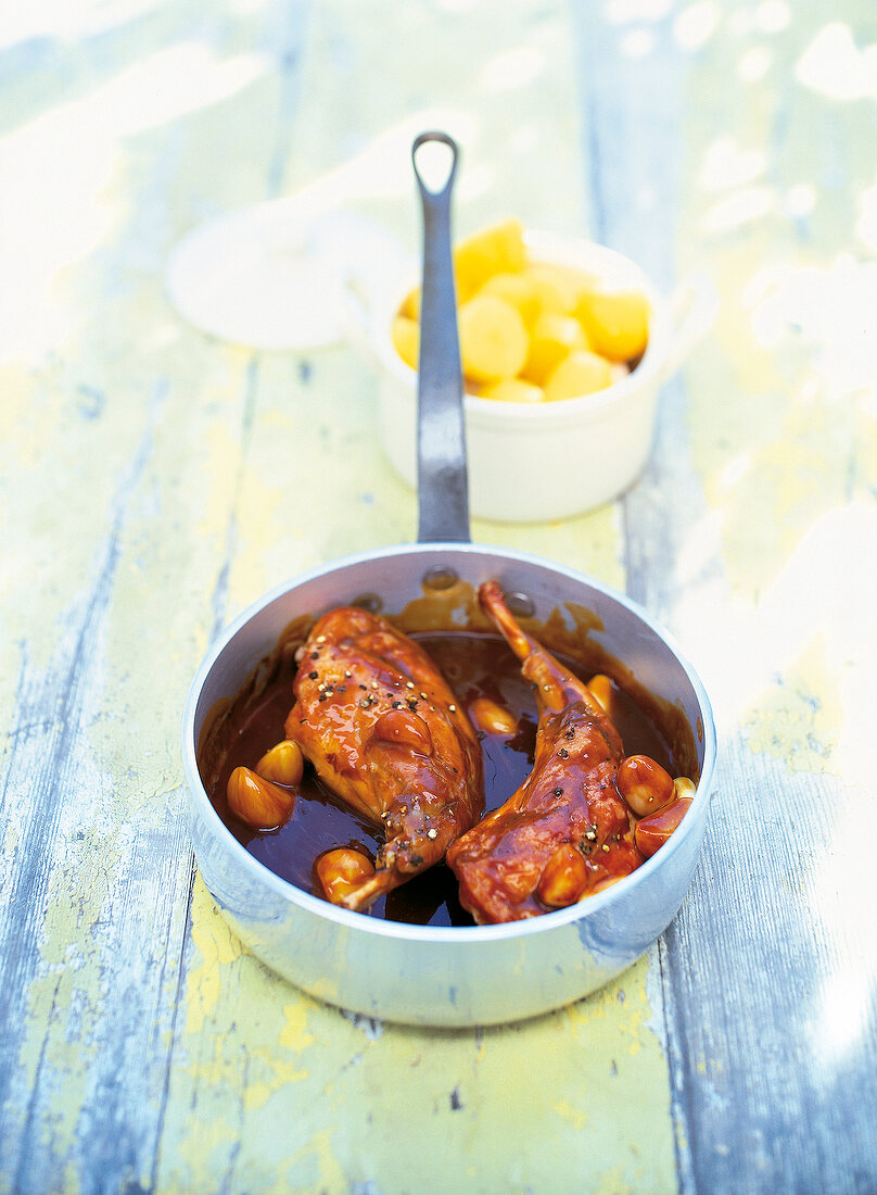 Rabbit legs with garlic in sauce pan