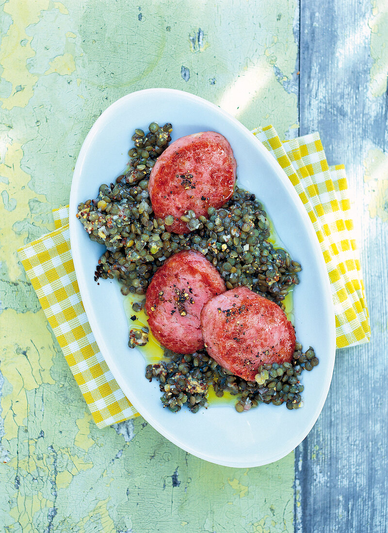 Lentil salad with cooked sausage on plate