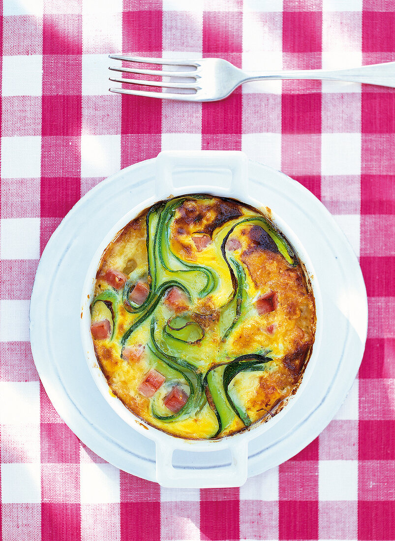 Zucchini gratin with ham on plate