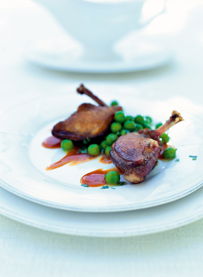 Pigeon breast with saffron and green peas on plate