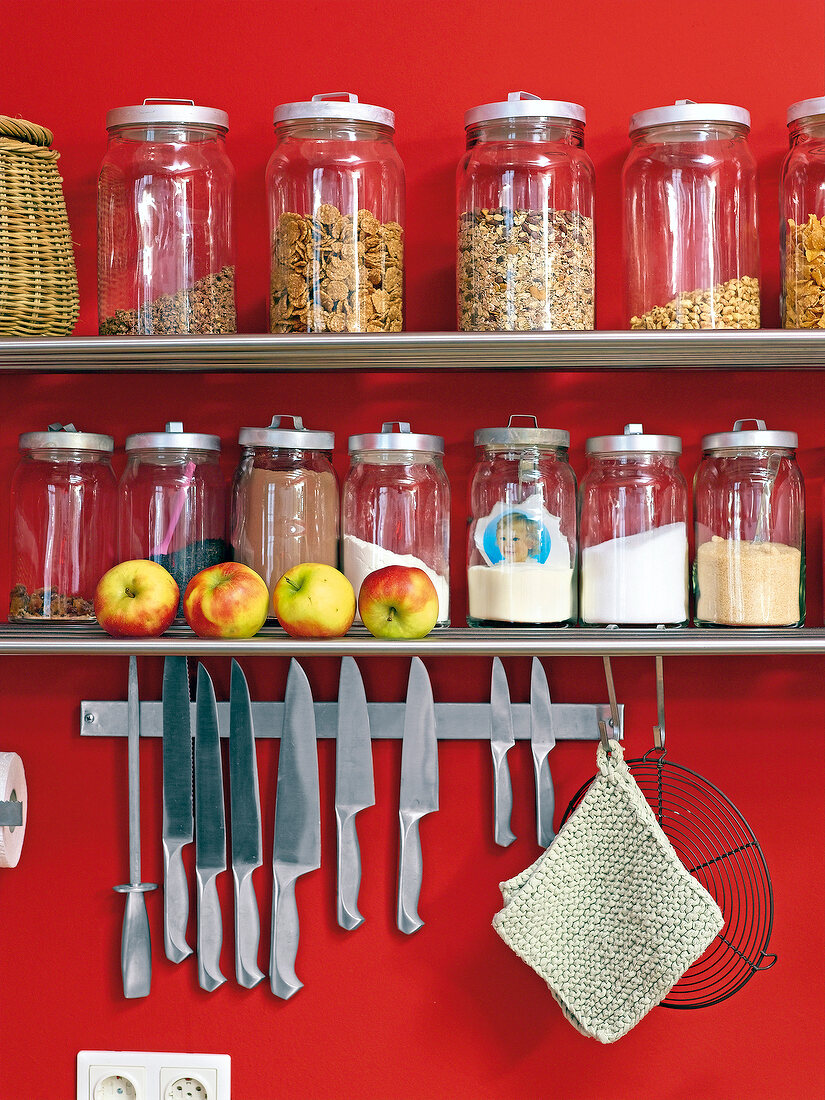 Knife hanging from magnetic bar under shelf with preserving jars