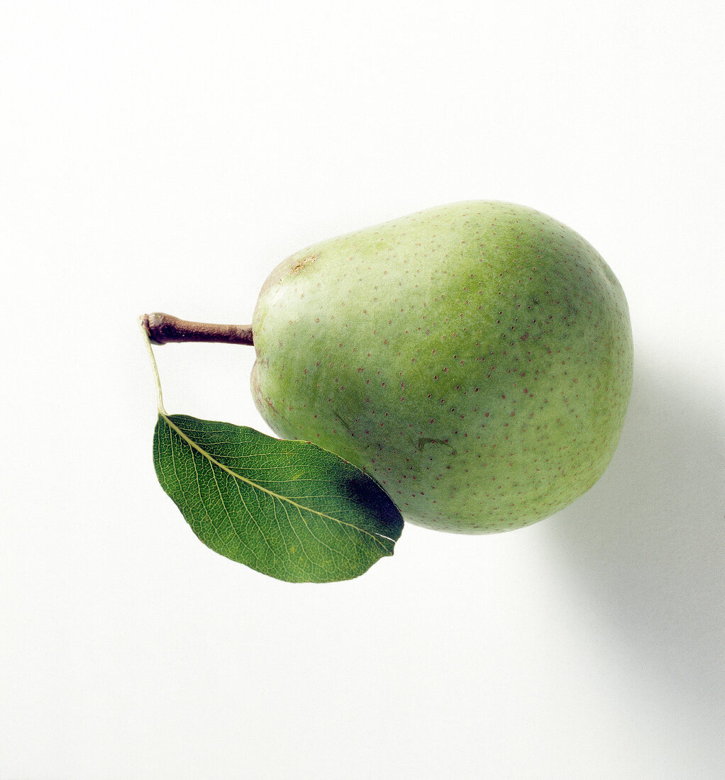 Close-up of pear with leaf on white background