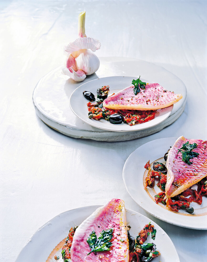 Rotbarbenfilet auf Sauce von ge- trockneten Tomaten, Oliven u. Kapern