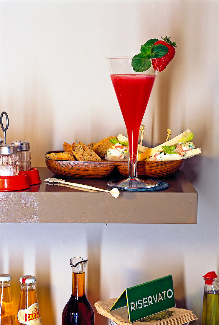 Rossini cocktail, rosemary walnut biscotti and tramezzini on table