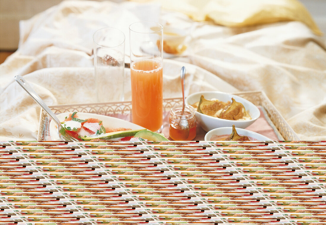 Fruit salad, baked figs and glass of juice on tray