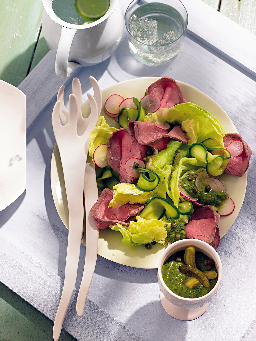Cucumber salad with roast beef on plate