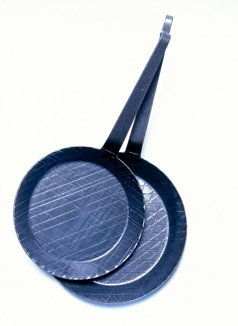 Two forged frying pans on white background