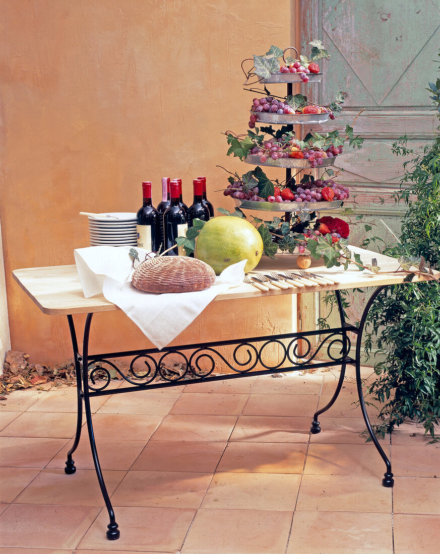 Country style table laid with drinks and fruits on garden terrace