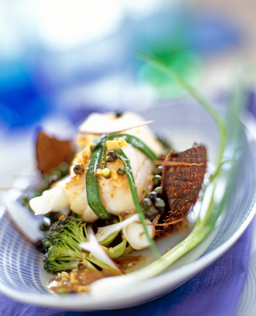 Close-up of cod with broccoli and peanut sauce on plate