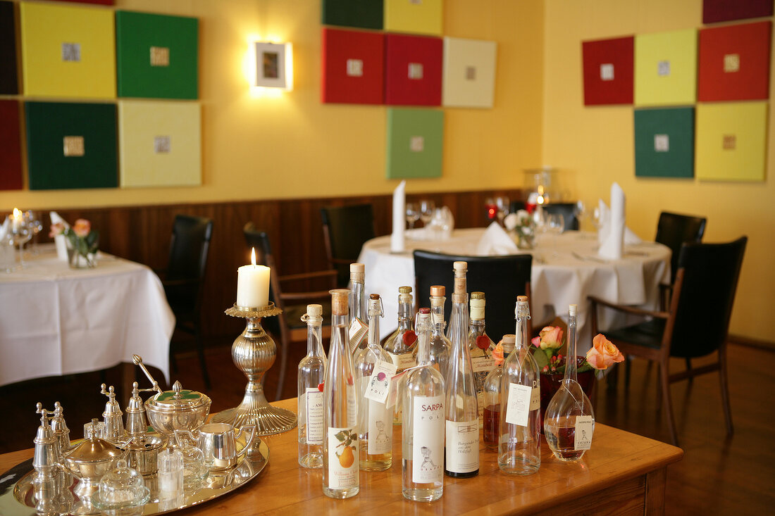 Various glasses and bottles on table in restaurant, Germany