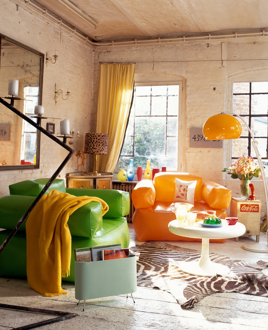 Green and orange large armchairs, side table, lamp and mirror in living room