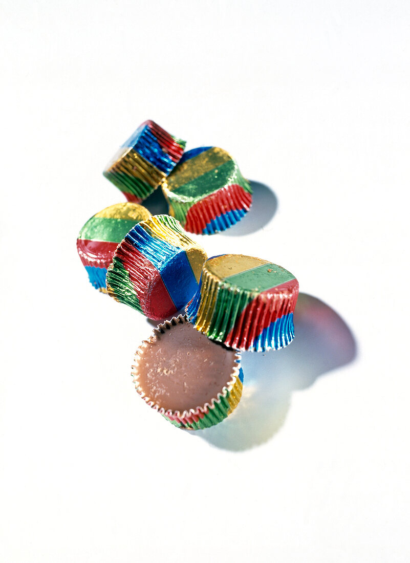 Several ice candy in colourful paper on white background