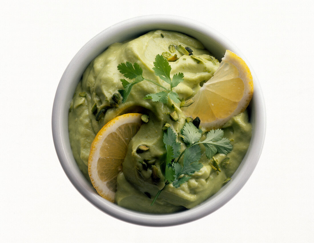Green pasta sauce with coriander and lemon in bowl