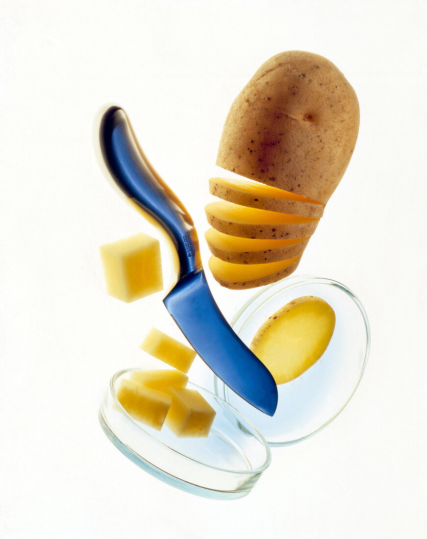 Unpeeled potato capped with knife and potato cubes in box