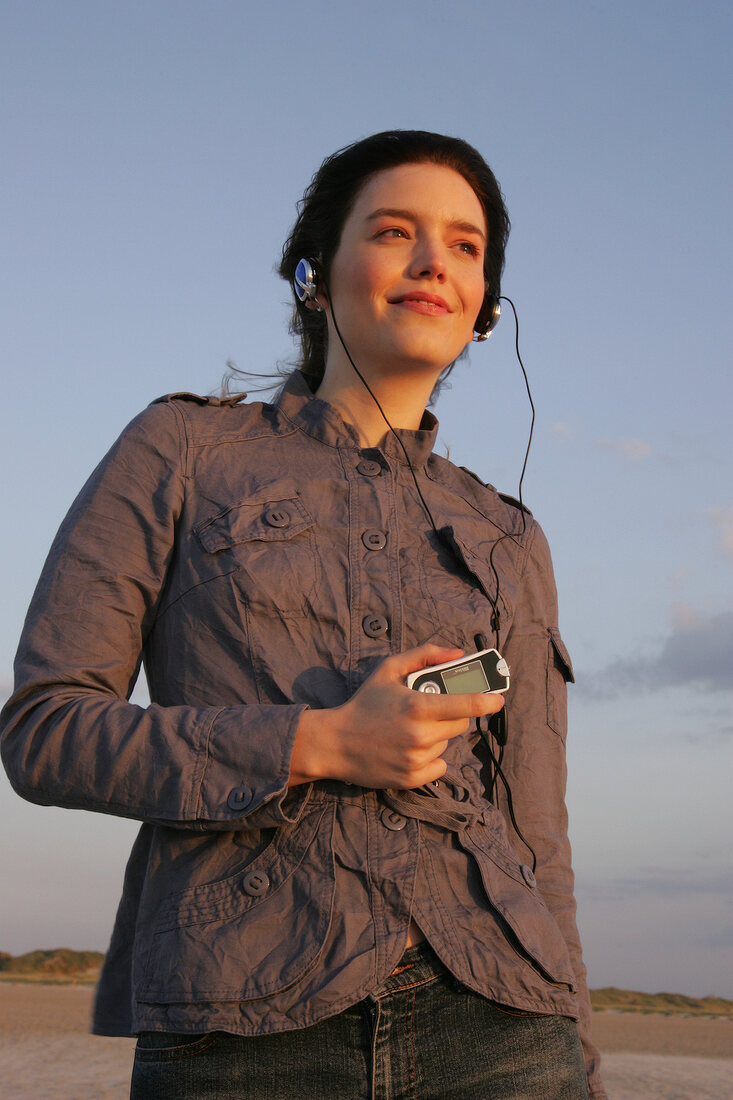 Janine Frau hört am Strand Musik