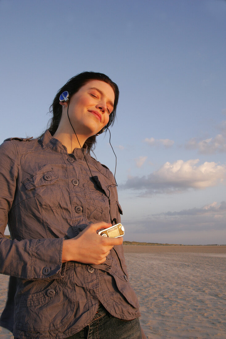 Janine Frau hört am Strand Musik