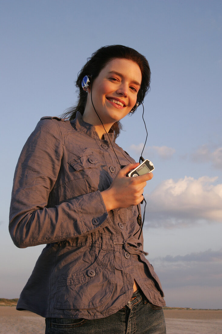 Janine Frau hört am Strand Musik