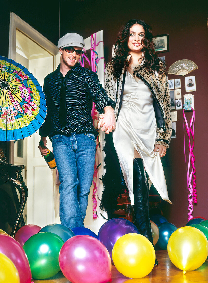 Paar feiert auf einer Party mit Sekt Luftballons