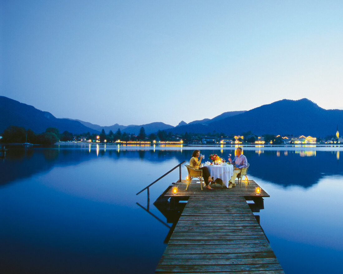 Couple dinning at a dock on the lake in night