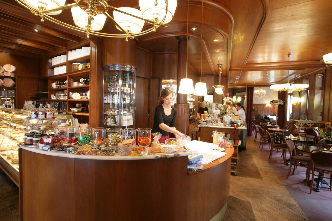 Woman working at counter of caf, Germany