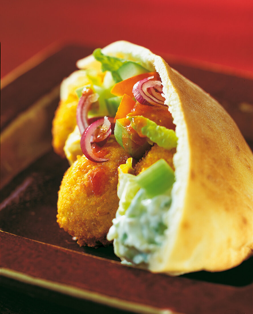 Close-up of Pita bread with falafel balls, tomatoes, onions and cucumbers