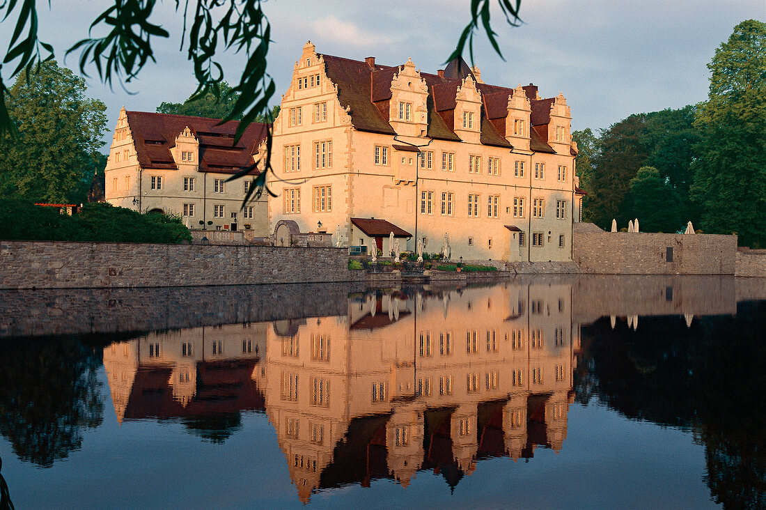 View of Schlosshotel Munchhausen and reflection in the pond at sunset