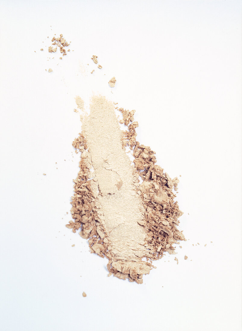 Close-up of loose powder of eye shadow on white background, overhead view