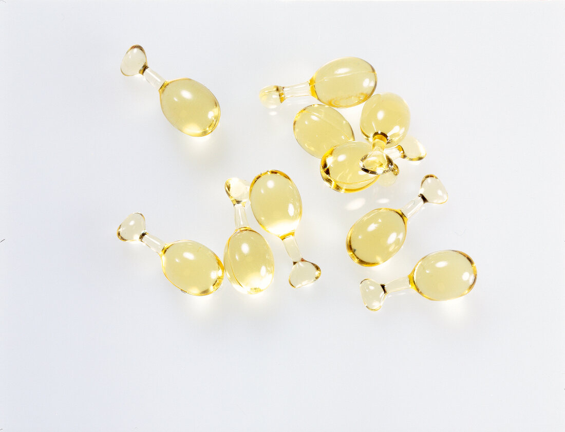 Yellow oil capsules on white background