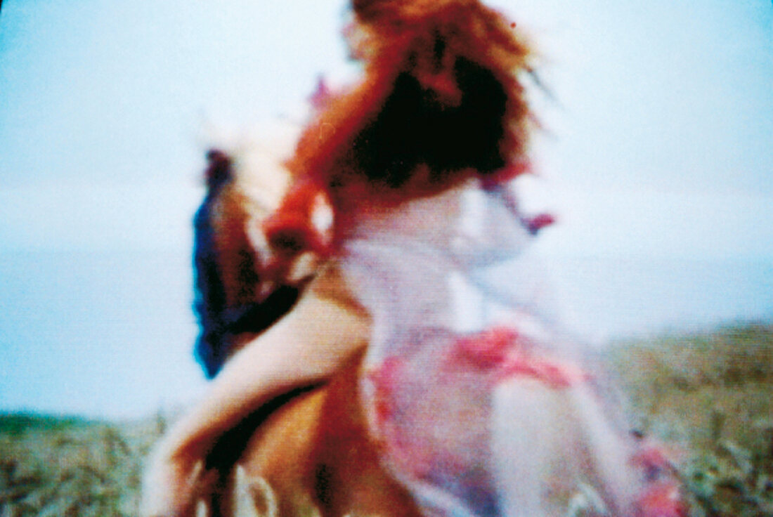 Frau mit wehendem Haar und Cape auf einem Pferd: Rückansicht