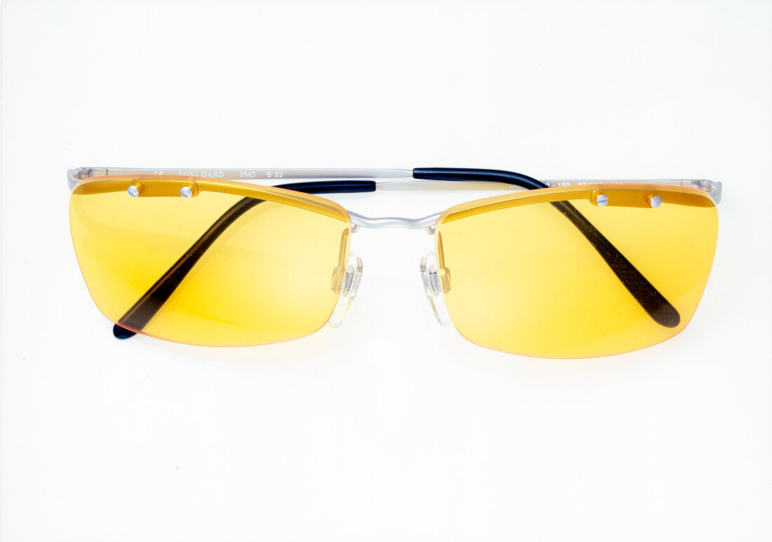 Close-up of rimless yellow sunglasses on white background