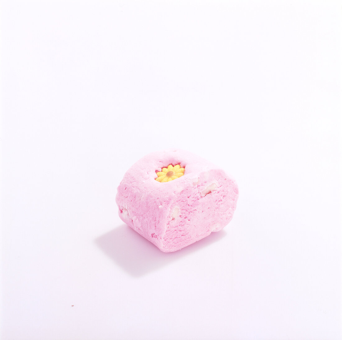 Piece of pink shower soap with yellow flower in it on white background
