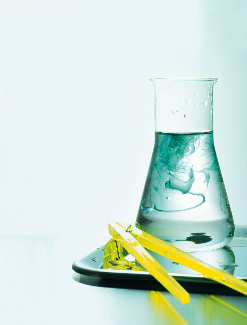 Laborglas mit Flüssigkeit auf einer Platte