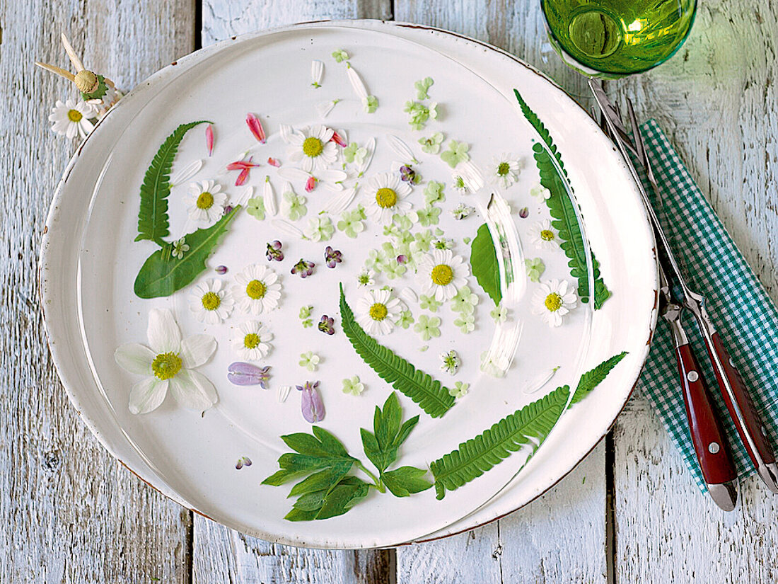 Freshly picked flowers on a place plate, with a glass plate above them