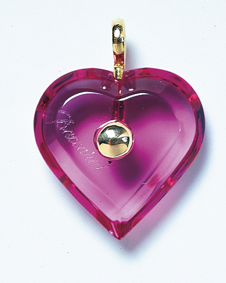Freisteller: Pinkes, geschliffenes Kristall-Herz mit Goldkugel