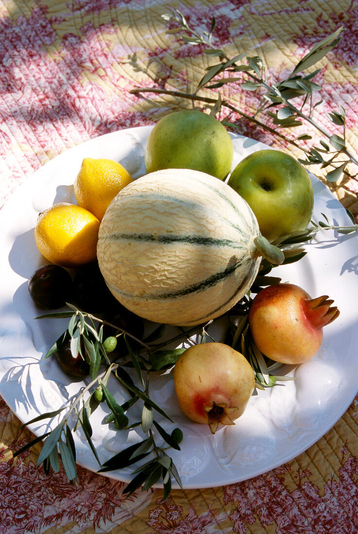 Apples, lemons, apples garnet, and melon on plate