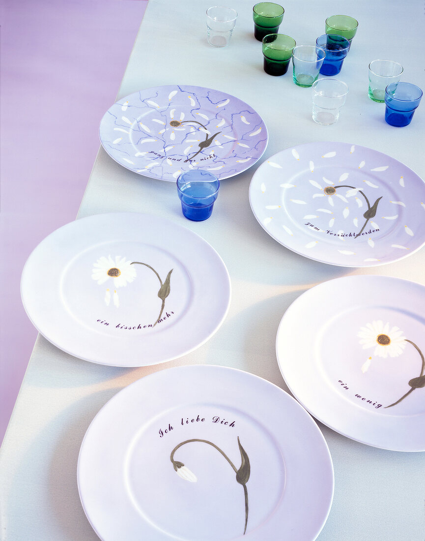 Plates with lilac daisy pattern on white table