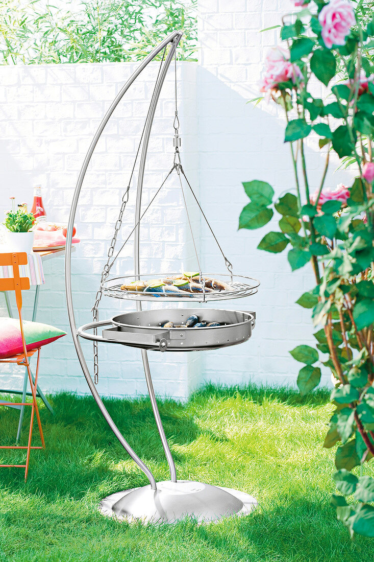 Silver pan and chrome grill made of stainless steel hanging in garden