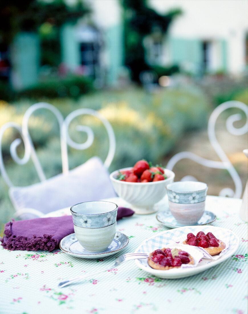 Table set with cups and strawberries