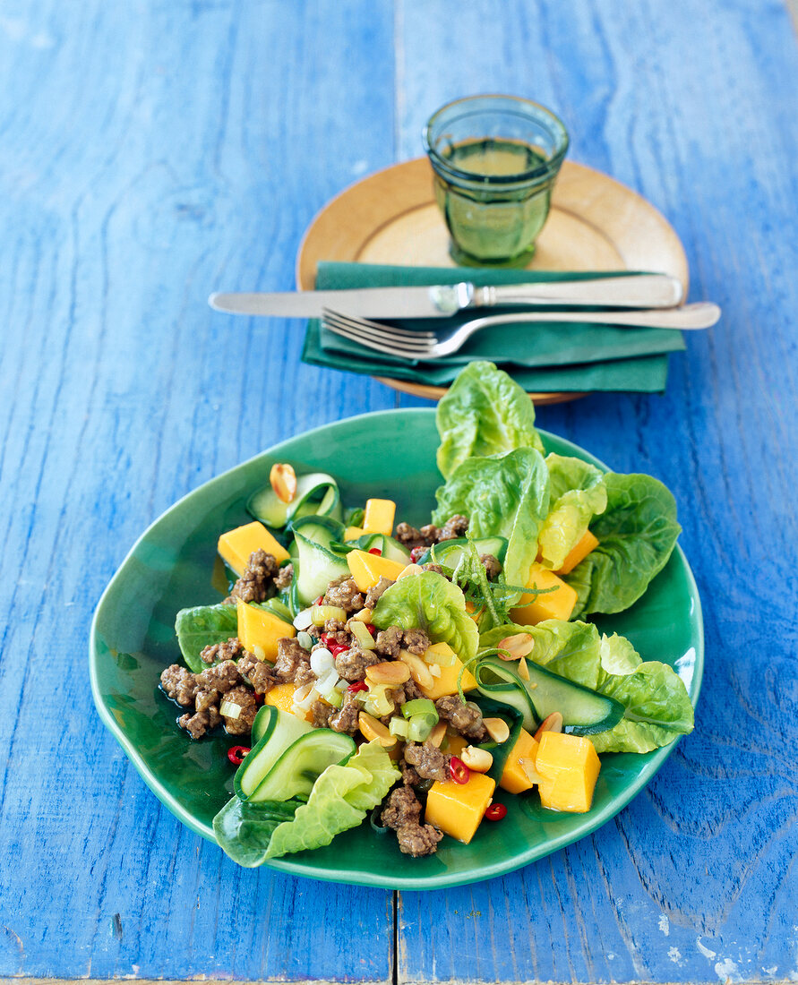 Salad with mango and cucumber on plate