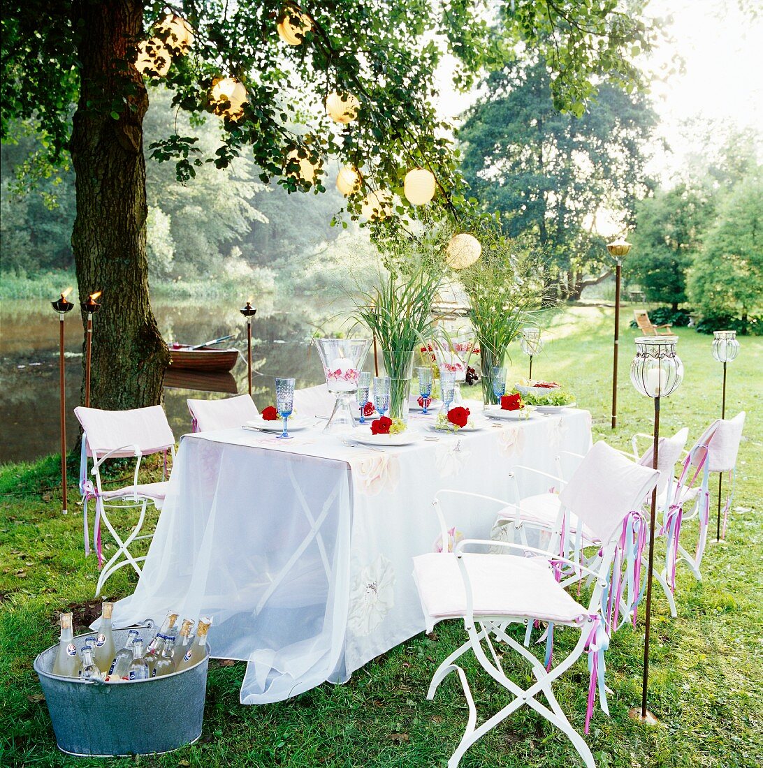 Gedeckter Tisch mit Blumendeko im Garten