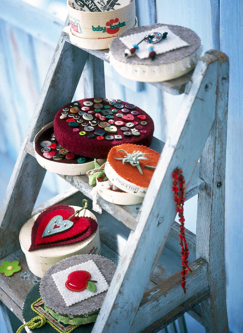 Chipboard boxes with stickers, emblems and button sewn on it