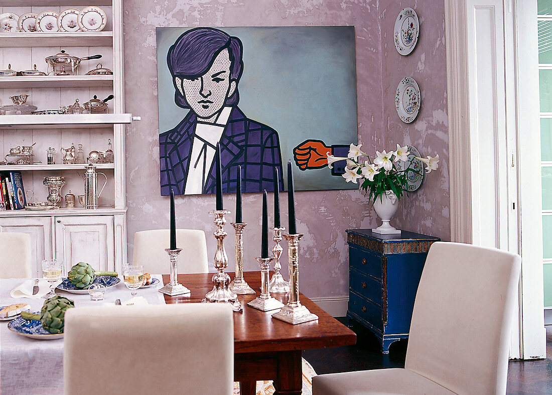 Esszimmer: gedeckter Tisch, silberne Kerzenhalter und Pop-Art-Gemälde