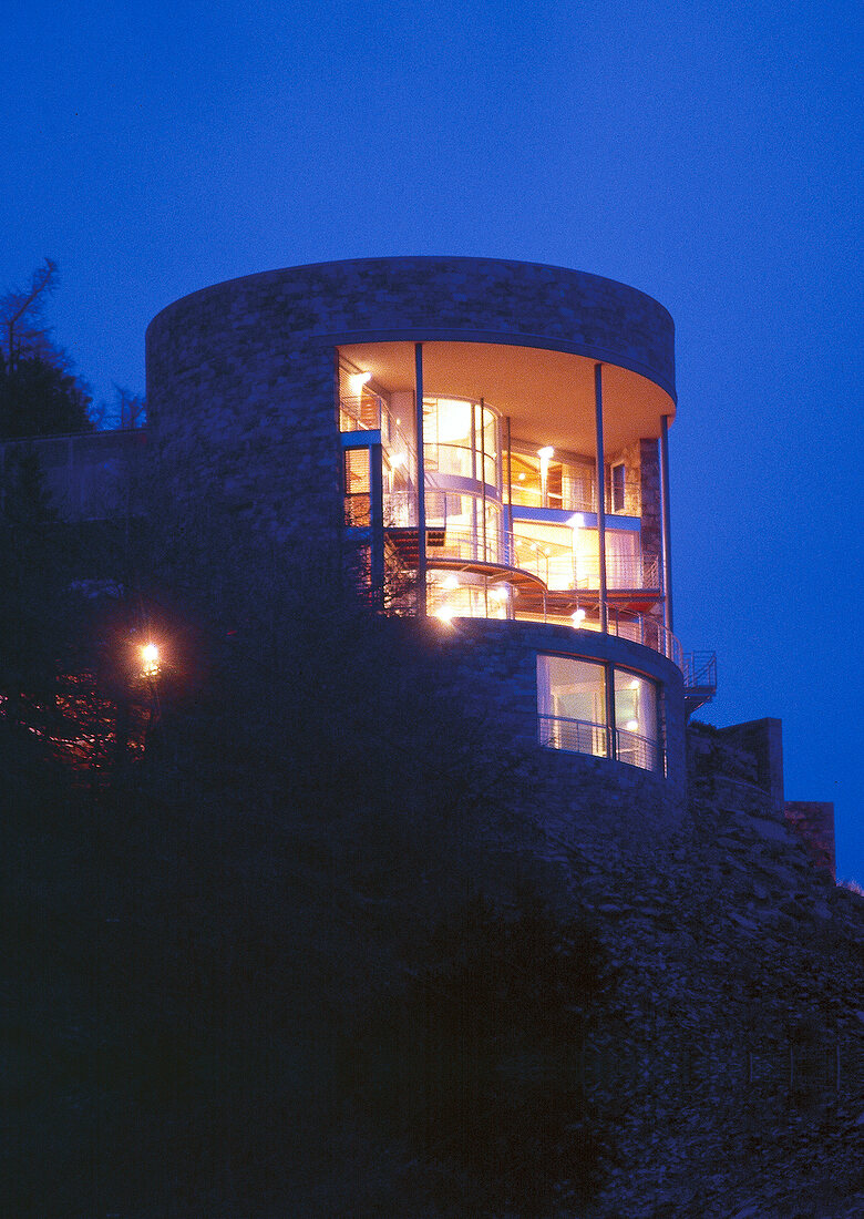 Modernes Wohnhaus mit Glasfront beleuchtet bei Nacht, Vinschgau