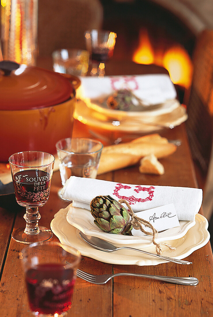 Glass of wine with artichoke on plate and name tag on dinning table